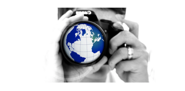Man using camera that has an image of a globe in the lense